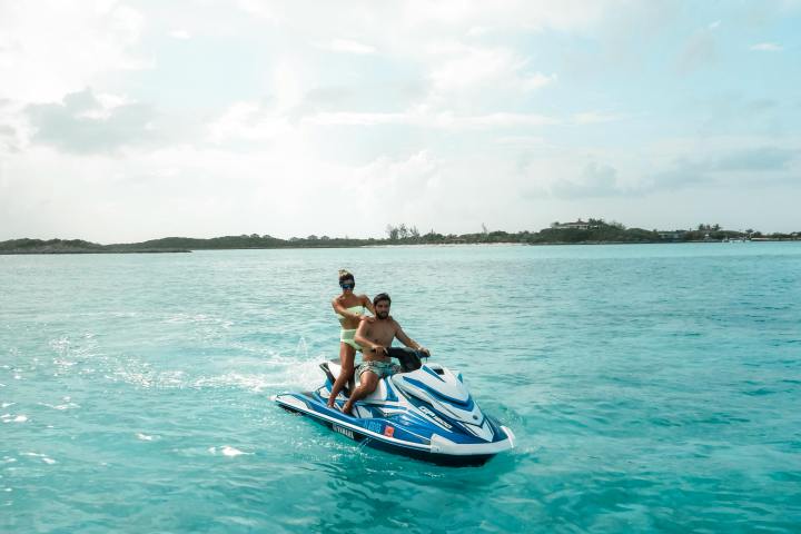 a man riding on the back of a boat in a body of water